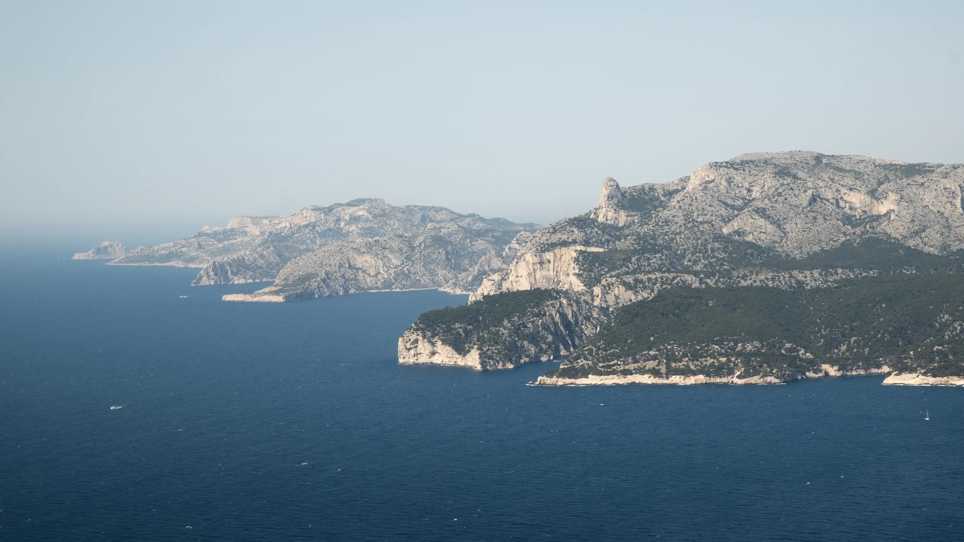 Limestone islands and headlands in a hazy blue sea